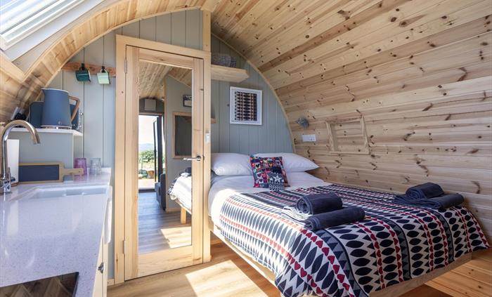 Luxury Glamping Pod. Nicely decorated with Welsh blankets, Hot water bottle and Calon Lan Cushion. Kitchenette area with Oven/microwave, Toaster and K